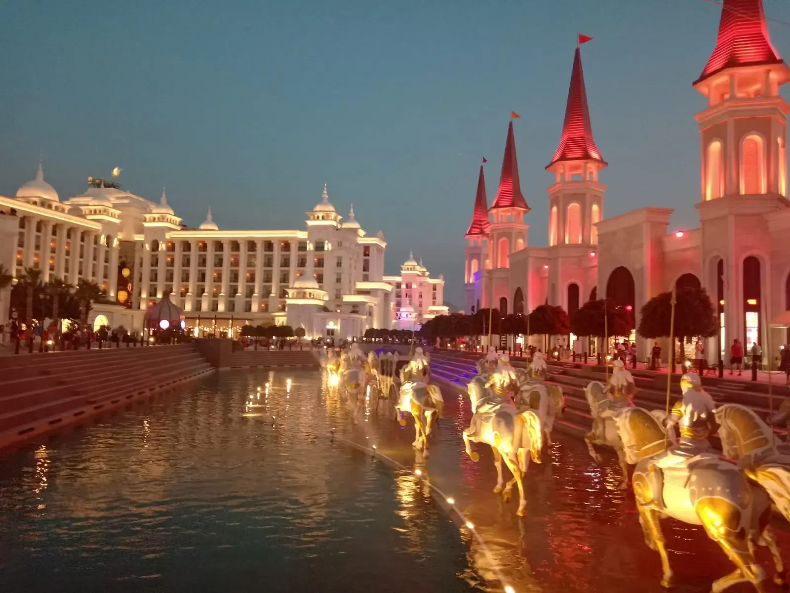 Het sprookjeskasteel en de fontein met paardenbeelden van The Land of Legends in Belek bij avondlicht