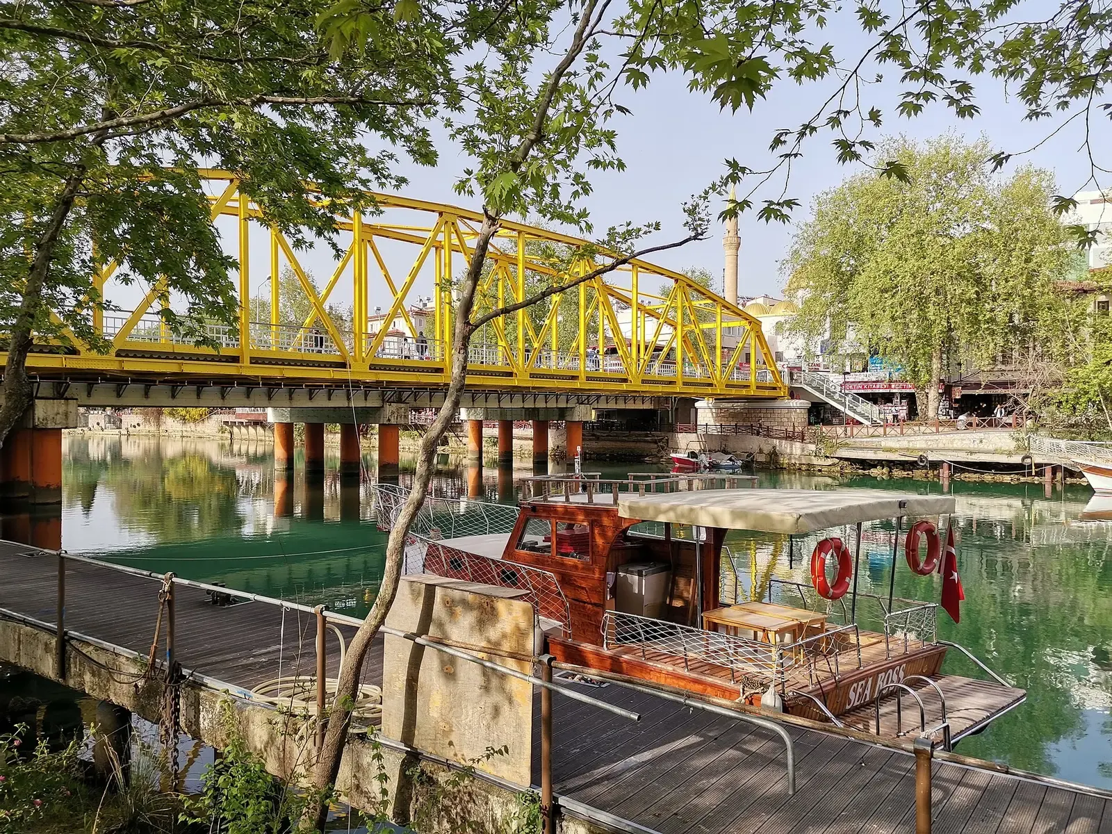 Rondvaartboot aan de steiger bij de gele brug over de Manavgat rivier