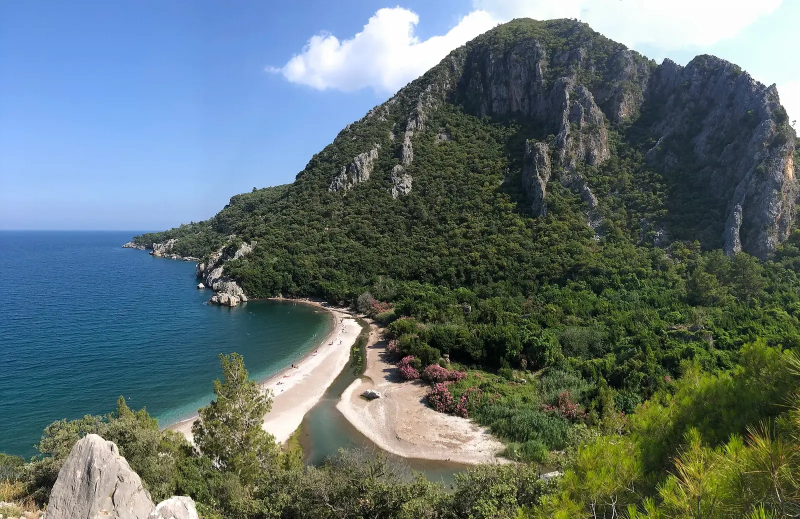 Het strand van Olympos met de beboste rotsen erboven, gezien vanaf de heuvel