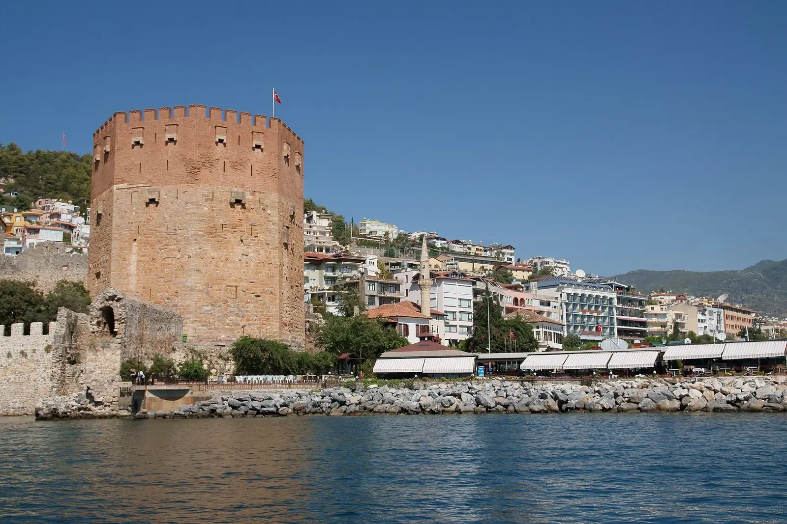 De achthoekige Rode Toren van Alanya aan de waterkant, gezien vanaf zee